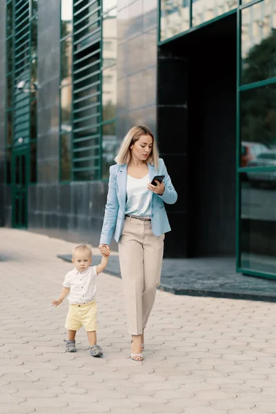 Portrait d'une femme d'affaires réussie en costume bleu avec bébé — Photo