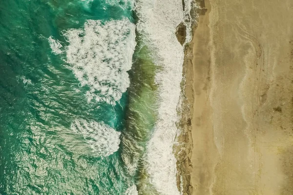Vista aérea de la arena encontrándose con el agua del mar y las olas — Foto de Stock