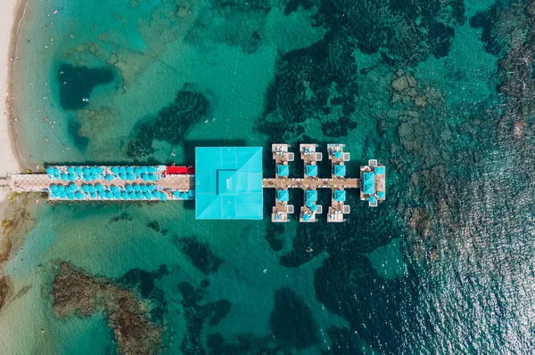 Вид с воздуха на пирсинг курорта в прозрачной морской воде со скалами — стоковое фото