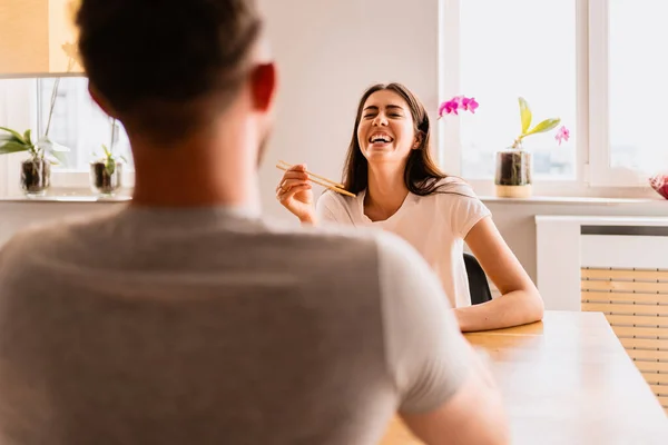 Сміється чоловік і жінка обідають разом вдома — стокове фото