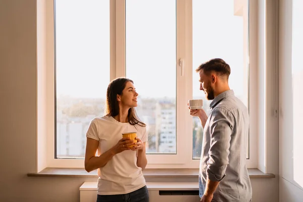 Ένας άντρας και μια γυναίκα πίνουν τσάι κοντά στο παράθυρο. — Φωτογραφία Αρχείου