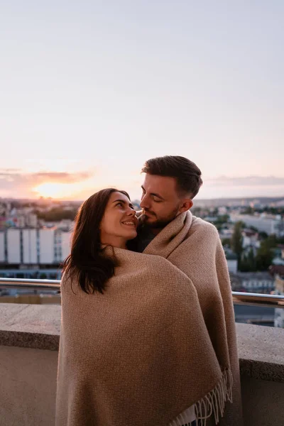 Mann und Frau auf Balkon bei Sonnenuntergang in der Stadt — Stockfoto