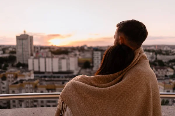 Hombre y mujer en el balcón al atardecer en la ciudad — Foto de Stock
