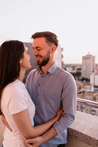 Mann und Frau auf Balkon bei Sonnenuntergang in der Stadt — Stockfoto