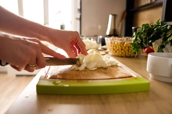 Manos de mujer, cortando cebollas — Foto de Stock