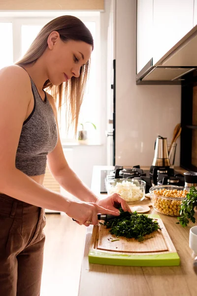 Mulher bonita dill corte na cozinha — Fotografia de Stock