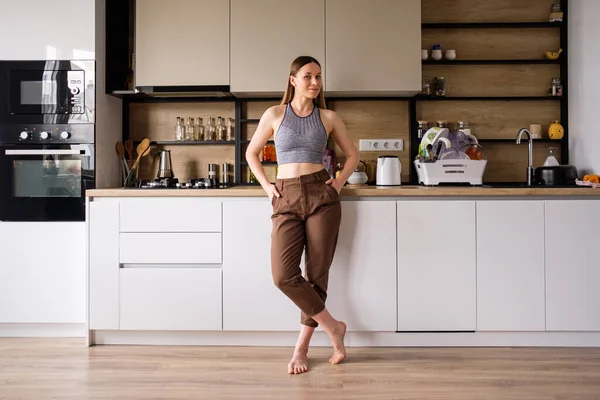 Молодая женщина позирует на современном кухонном фоне — стоковое фото