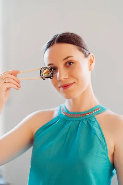 Fröhliche Frau mit Sushi-Rolle am Auge. — Stockfoto