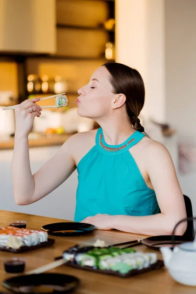 Jovem mulher saboreando seu sushi — Fotografia de Stock