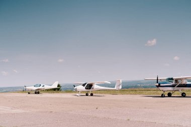 Arka planda gökyüzü ile havalanmayı bekleyen küçük pervaneli spor uçak. Özel uçaklar