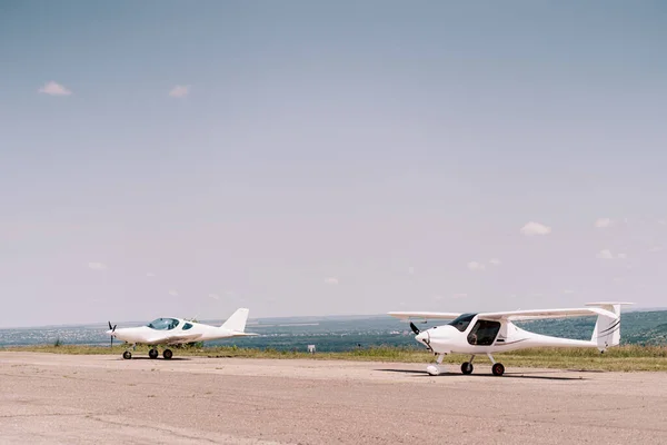 stock image Small propeller sport airplane in the field waiting to take off with sky in background. Private airplanes