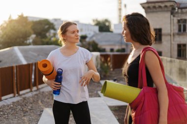 Spor giyimli iki güzel kadın spor antrenmanı, jimnastik ve yoga yapacaklar.