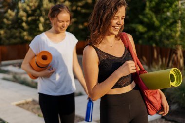 Spor giyimli iki güzel kadın spor antrenmanı, jimnastik ve yoga yapacaklar.