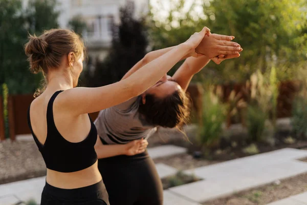 Две молодые девушки практикующие растяжку и упражнения йоги тренировки вместе — стоковое фото