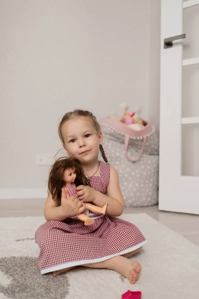 Маленькая девочка играет с куклой — стоковое фото