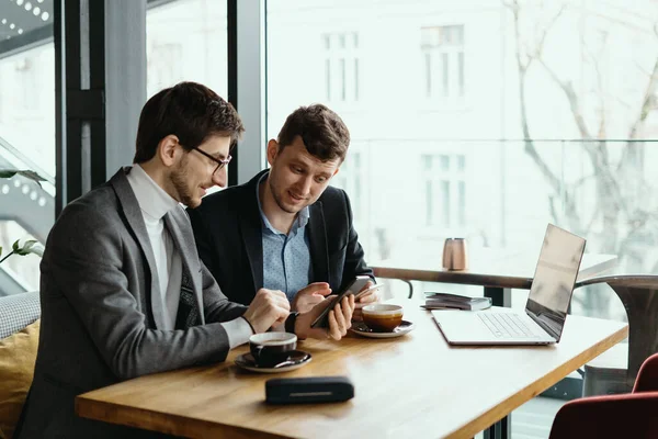 Twee jonge zakenman hebben een succesvolle vergadering in restaurant. — Stockfoto