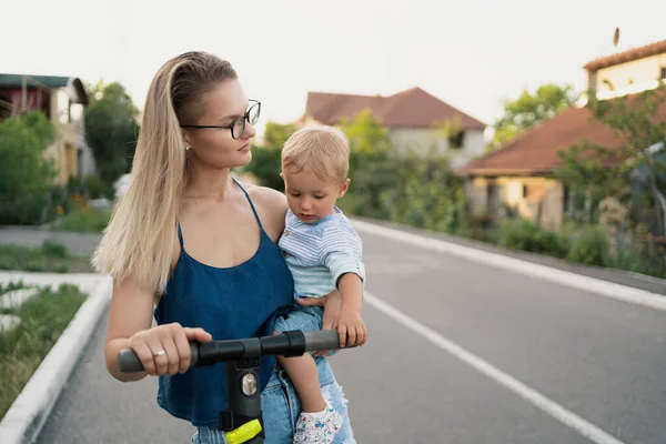 Mère et fils chevauchant un scooter électrique — Photo