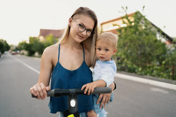 Madre e hijo montando un scooter eléctrico —  Fotos de Stock