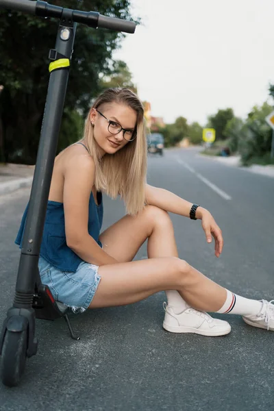 Milenial mujer montando un scooter eléctrico en la calle —  Fotos de Stock