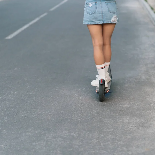 Millennial mulher montando uma scooter elétrica na rua — Fotografia de Stock