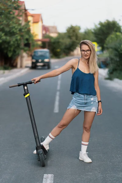 Millennial kobieta jazda na skuterze elektrycznym na ulicy — Zdjęcie stockowe
