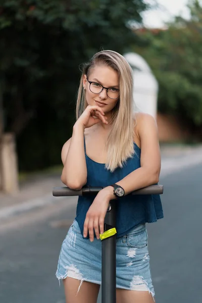 Milenial mujer montando un scooter eléctrico en la calle —  Fotos de Stock