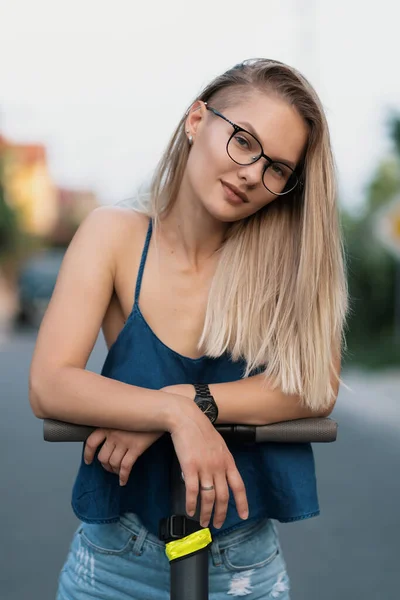 Milenial mujer montando un scooter eléctrico en la calle —  Fotos de Stock