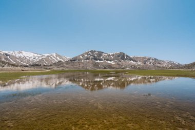 Dağlar göl suyuna yansıyor