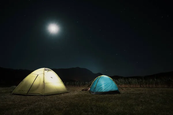 Tentes touristiques dans le camp parmi les prairies dans les montagnes de nuit — Photo