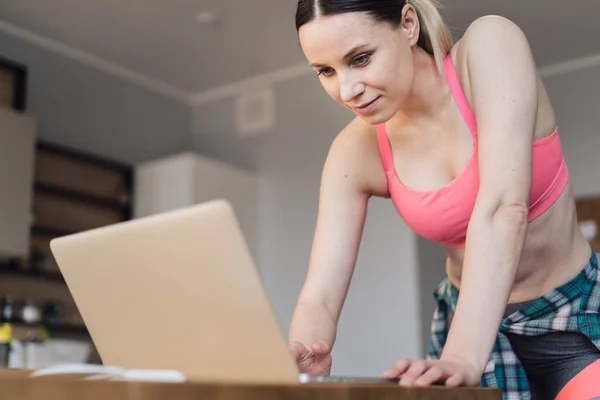 Mulher procurando esportes vídeo aulas no laptop — Fotografia de Stock