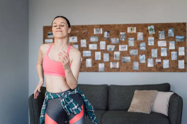 Glimlachende vrouw dansen in het midden van de woonkamer genieten van zichzelf en het leven — Stockfoto