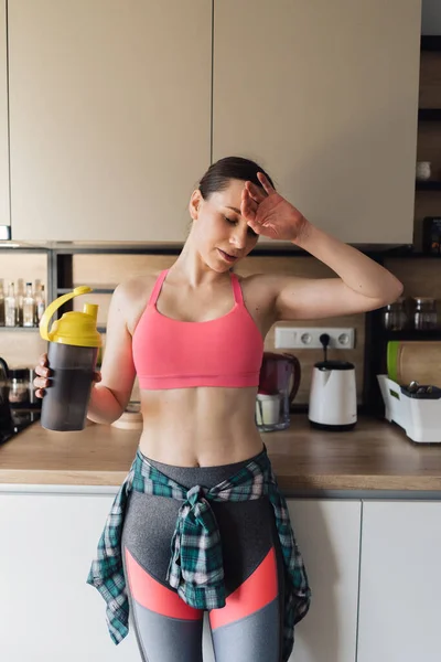 Восхитительная женщина пьет воду после тренировки дома — стоковое фото