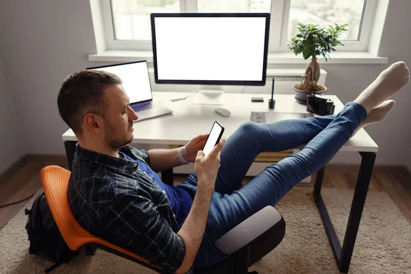 Modern man på hemmakontoret kopplar av med benen på bordet — Stockfoto