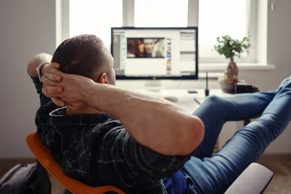 Homem moderno em casa escritório relaxante com as pernas na mesa — Fotografia de Stock