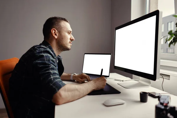 Молодий чоловік працює з інтерактивним дисплеєм і комп'ютером — стокове фото