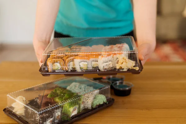Mulher segurando caixa de sushi para entrega — Fotografia de Stock