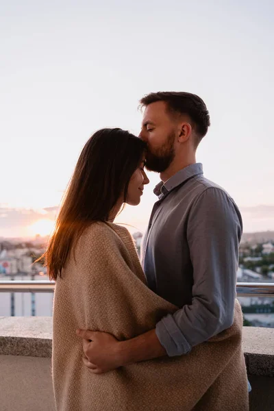 Mann und Frau auf Balkon bei Sonnenuntergang in der Stadt — Stockfoto