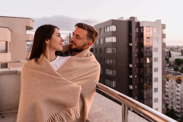 Homem e mulher na varanda ao pôr do sol na cidade — Fotografia de Stock