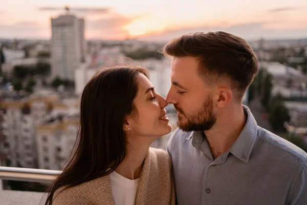 Hombre y mujer en el balcón al atardecer en la ciudad —  Fotos de Stock