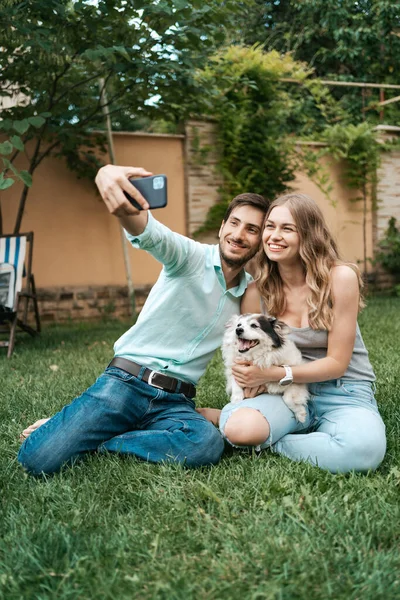 Jeune couple faisant selfie avec leur beau chien — Photo