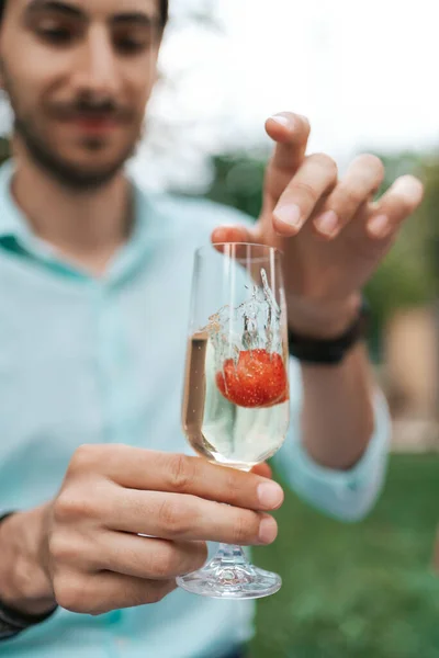 Mano de hombre sosteniendo una copa con vino espumoso — Foto de Stock