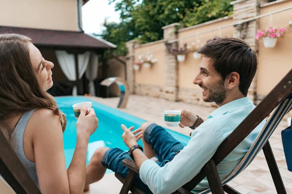 Hombre y mujer pasan tiempo juntos cerca de la piscina tomando té — Foto de Stock