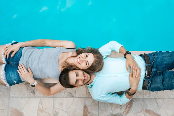 Couple d'amour couché près de la piscine — Photo