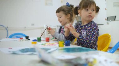 Çocuk oyun odası geliştirmek. Sınıflar eğlenceli sırasında duygular genç çocuk. çocuk beyaz yaprak kağıt üzerinde parmak boya ile boyayın. Çocuk beyaz kirli elleriyle silin