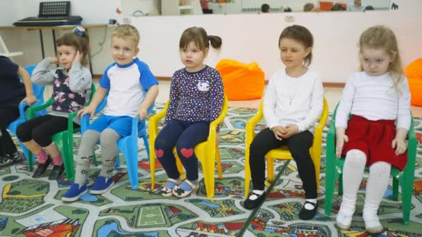 Kinder entwickeln ein Spielzimmer. Emotionen von Kleinkindern während unterhaltsamer Unterrichtsstunden. Kind baut eine fröhliche Miene auf. Possen bauen Kinder lustige Gesichter auf. Menschen kneten sich vorher den Mund zu — Stockvideo