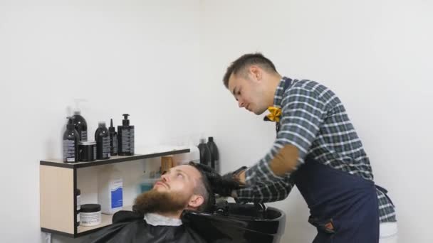 Férfi fodrászat. Fodrászatban. Caring részére a szakáll. Fodrász hajvágó, működik a frizura a szakállas fickó fodrászatban háttér. Csípő életmód fogalma. A clipper vágás haj fodrász — Stock videók