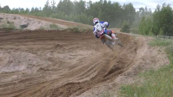 Junho 10, 2018 Federação Russa, região de Bryansk, Ivot - Esportes radicais, cross motocross. O motociclista entra na curva na pista de corrida. A terra está a voar debaixo das rodas. A máquina — Vídeo de Stock