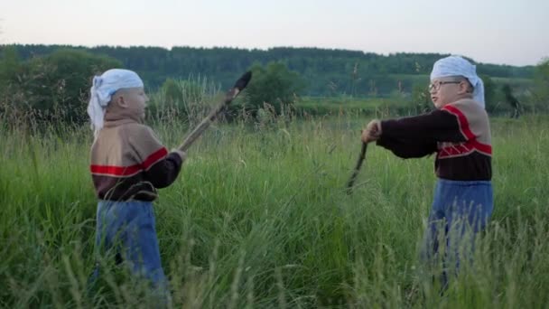 Vonken van het branden van de stokken. Slag bij kinderen te branden dubankah. kinderen strijden in een schone groene veld. Kolen uit brandende stokken scatter in verschillende richtingen. Slow motion — Stockvideo