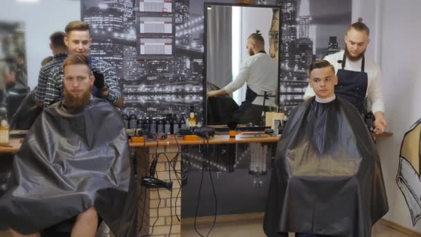 Kapsalon voor mannen. Kapsalon. Verzorging van de baard. Kapper met een kapsel werkt voor een kapsel voor een bebaarde man. Het concept van een hipster-levensstijl. Kapper Sun Hipster krijgt een kapsel. een — Stockvideo