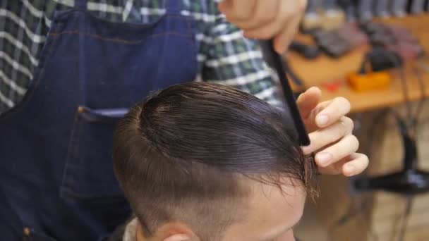 男士美发师 理发店 理发美发的发型师为一个大胡子的人做头发 时髦的生活方式的概念 理发师把顾客的头分开了 — 图库视频影像